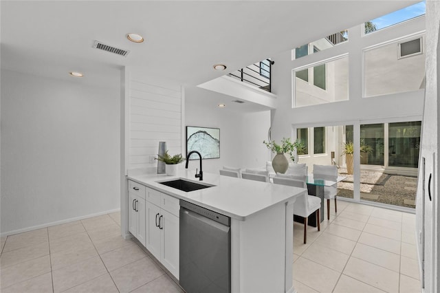 3101 W El Prado Blvd Unit B, Tampa, FL 33629 - kitchen with stainless steel dishwasher, a sink, light tile patterned flooring, light countertops, and white cabinetry