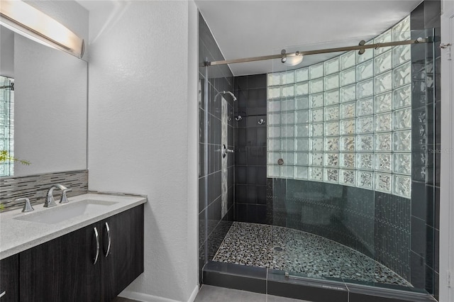 3101 W El Prado Blvd Unit B, Tampa, FL 33629 - bathroom featuring a shower stall, vanity, a textured wall, and tasteful backsplash