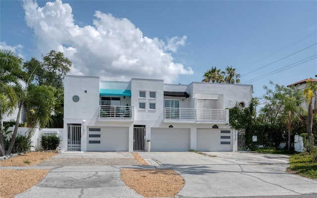 3101 W El Prado Blvd Unit B, Tampa, FL 33629 - art deco inspired home featuring stucco siding, a balcony, driveway, and an attached garage