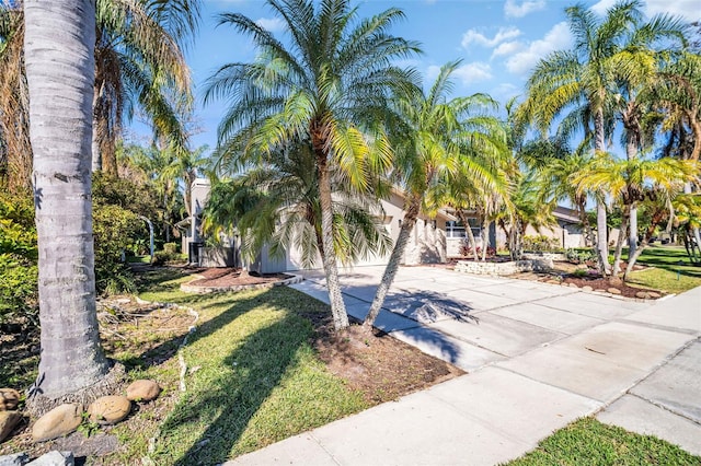 view of front of property with a garage, concrete driveway, and a front yard