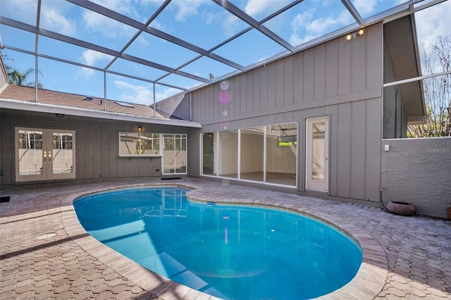 outdoor pool featuring a lanai, a patio, and french doors