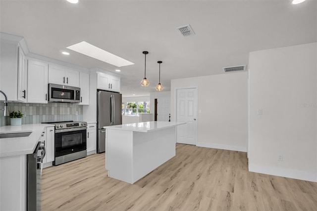 kitchen featuring tasteful backsplash, a kitchen island, visible vents, and stainless steel appliances