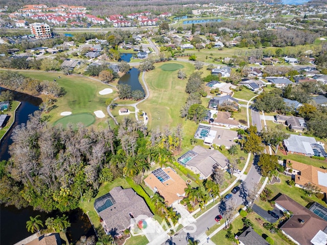 drone / aerial view with view of golf course, a water view, and a residential view