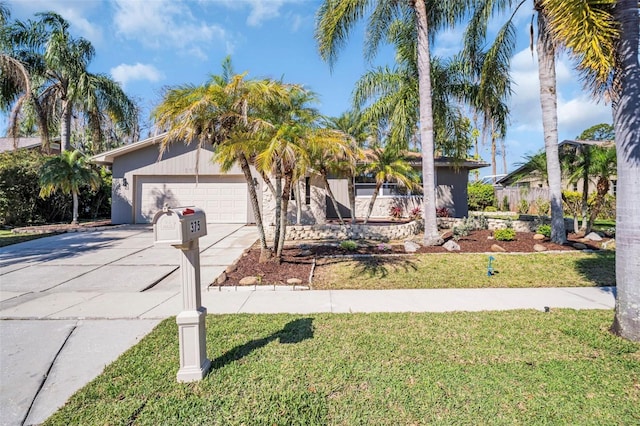 view of front of house with a front yard, concrete driveway, and an attached garage