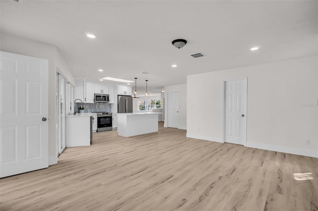 unfurnished living room featuring light wood-style floors, baseboards, visible vents, and recessed lighting