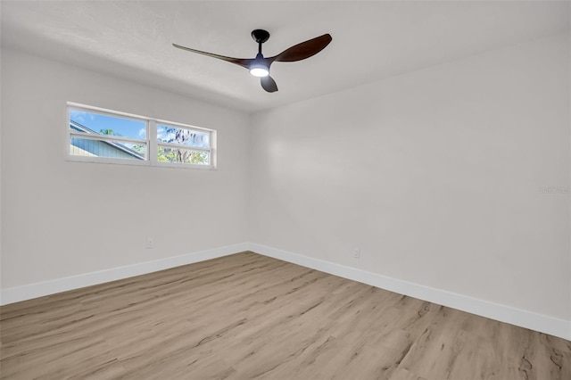 unfurnished room with light wood-style floors, a ceiling fan, and baseboards