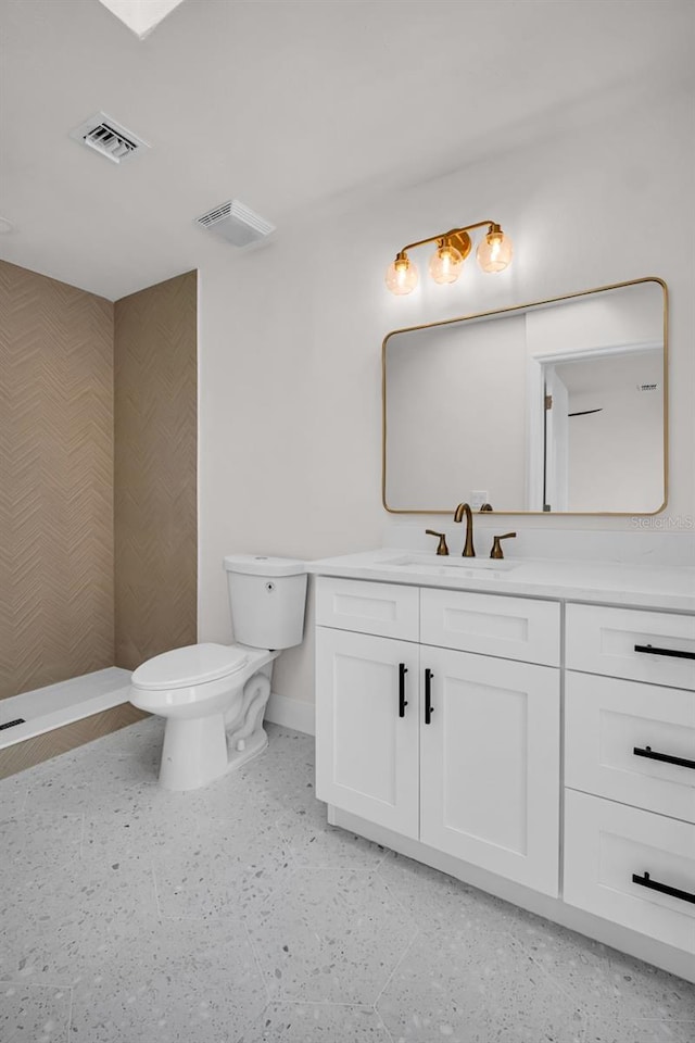 bathroom featuring baseboards, visible vents, vanity, and toilet