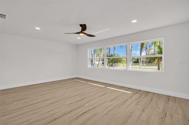 unfurnished room with plenty of natural light, wood finished floors, and baseboards