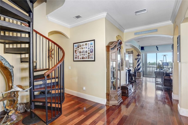 stairs with ornamental molding, visible vents, baseboards, and wood finished floors