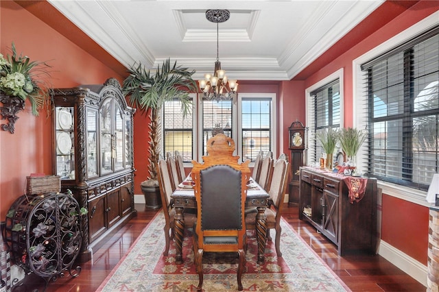 dining area featuring dark wood-style floors, a chandelier, a raised ceiling, and ornamental molding