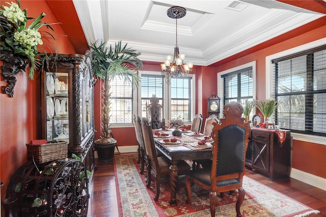 dining area with a chandelier, visible vents, a tray ceiling, wood-type flooring, and crown molding