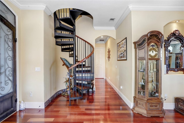 entryway featuring ornamental molding, arched walkways, baseboards, and wood finished floors