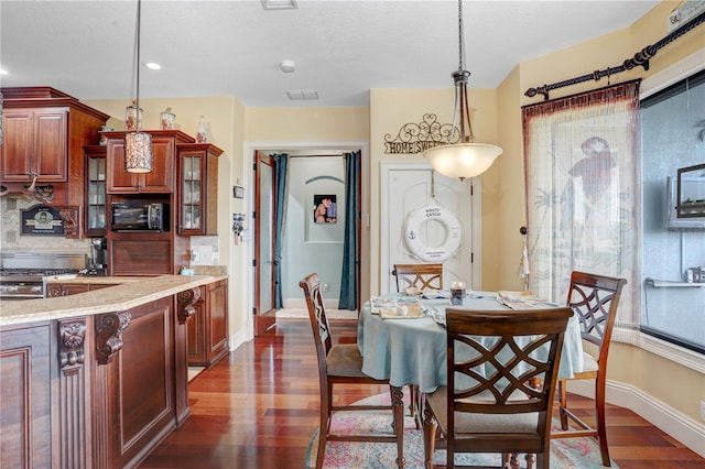 dining space with visible vents, baseboards, dark wood finished floors, and a textured ceiling