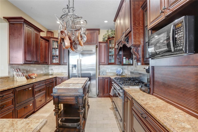 kitchen featuring stainless steel appliances, glass insert cabinets, decorative backsplash, and light stone counters