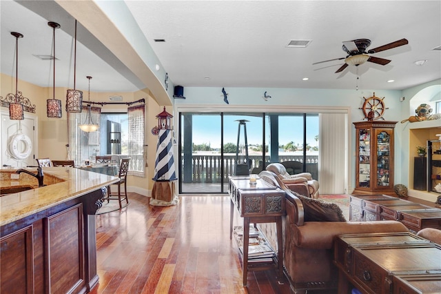 living area featuring recessed lighting, visible vents, a ceiling fan, wood finished floors, and baseboards