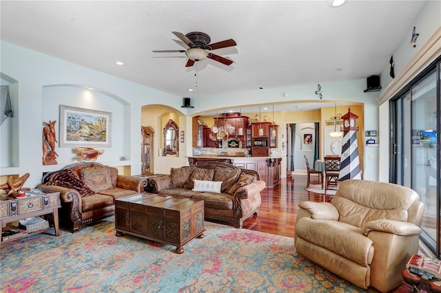 living room with light wood-type flooring, ceiling fan, a textured ceiling, and recessed lighting