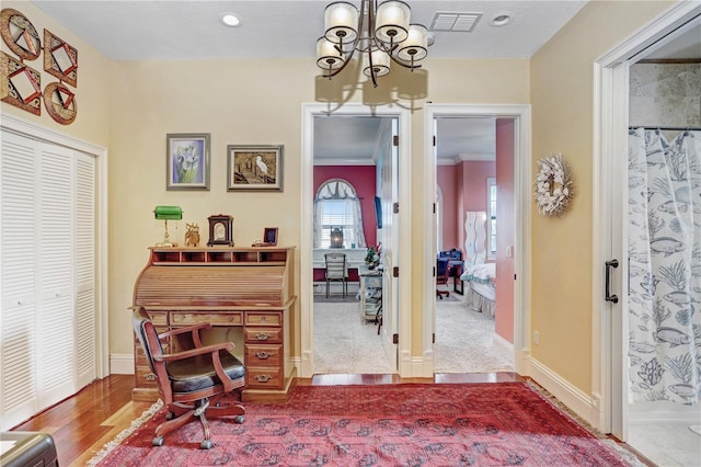 office area featuring baseboards, visible vents, a chandelier, and wood finished floors