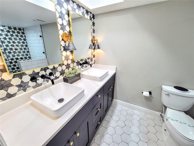 bathroom with a sink, backsplash, and toilet