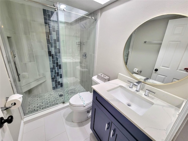 bathroom with vanity, a shower stall, toilet, and tile patterned floors