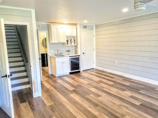 kitchen with beverage cooler, white cabinetry, light wood-style floors, light countertops, and open shelves