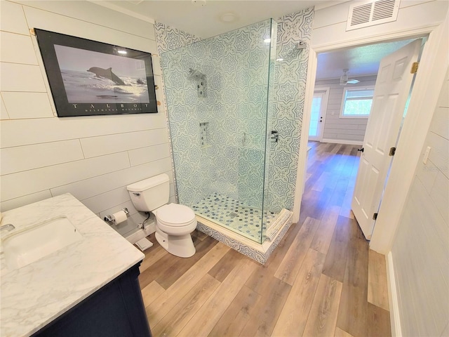 full bathroom with visible vents, toilet, wood finished floors, walk in shower, and vanity