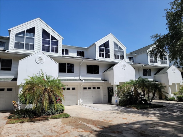 multi unit property featuring concrete driveway and an attached garage