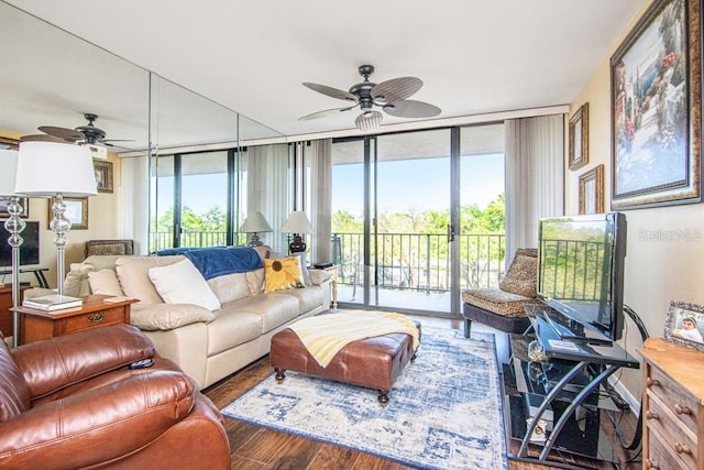 living area featuring expansive windows, ceiling fan, and wood finished floors