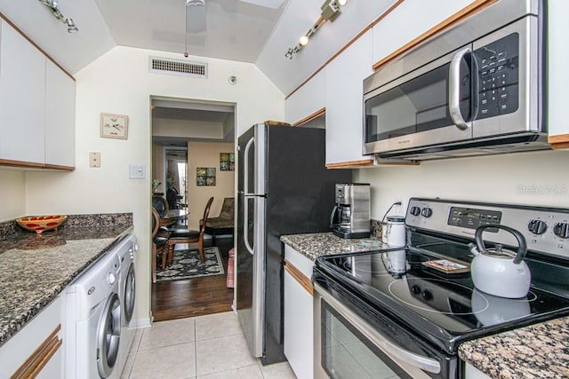 kitchen featuring light tile patterned floors, visible vents, white cabinets, appliances with stainless steel finishes, and washer / clothes dryer