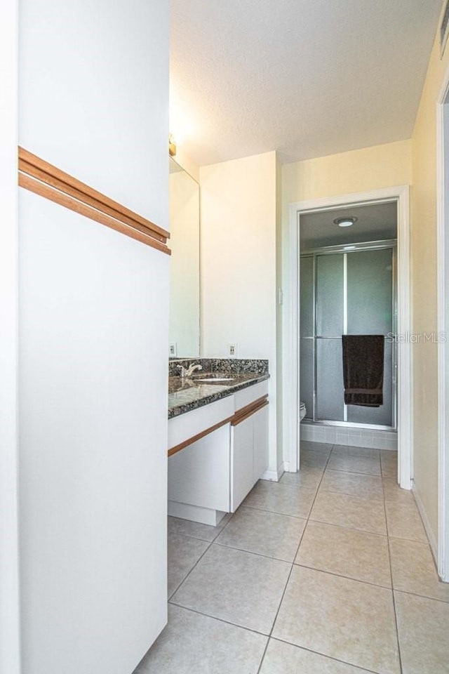 bathroom featuring toilet, tile patterned flooring, and vanity