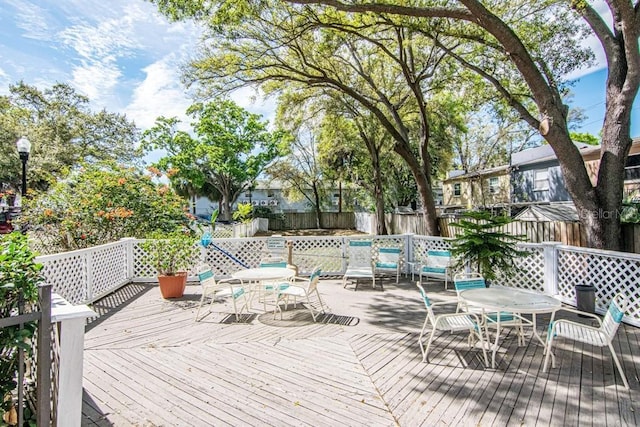 deck featuring outdoor dining space and a fenced backyard