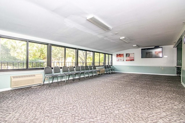 carpeted spare room featuring baseboards, vaulted ceiling, and a wall mounted air conditioner