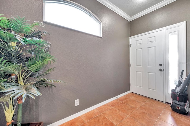 foyer entrance featuring light tile patterned floors, a textured wall, baseboards, and crown molding