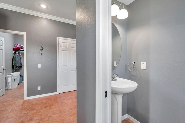 bathroom featuring tile patterned flooring, crown molding, and baseboards