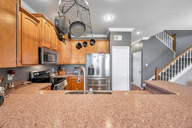 kitchen featuring a textured ceiling, a sink, visible vents, light countertops, and appliances with stainless steel finishes