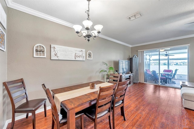 dining area featuring ornamental molding, wood finished floors, visible vents, and baseboards