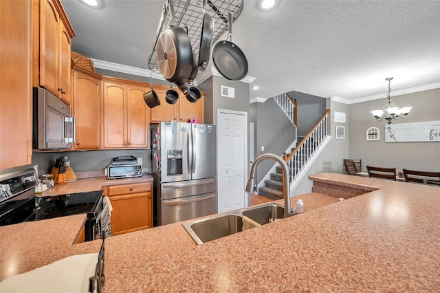 kitchen with visible vents, appliances with stainless steel finishes, ornamental molding, light countertops, and a sink