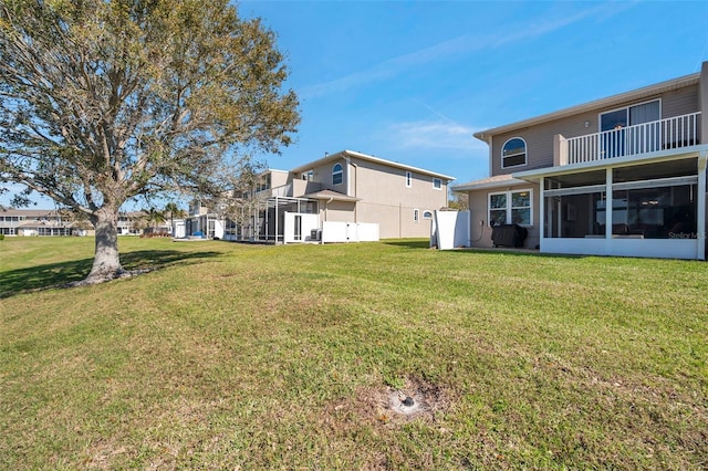 view of yard featuring a balcony and a sunroom