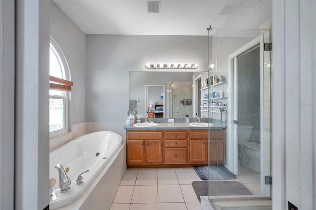 full bath with visible vents, toilet, a sink, tile patterned flooring, and a tub with jets