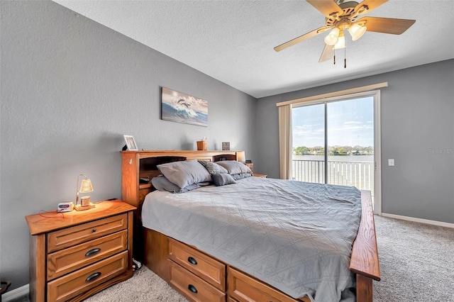 bedroom with access to exterior, light colored carpet, a ceiling fan, a textured ceiling, and baseboards