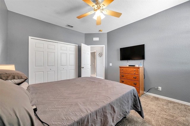 bedroom featuring baseboards, visible vents, a ceiling fan, carpet, and a closet