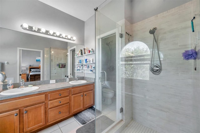 ensuite bathroom with a shower stall, double vanity, a sink, and connected bathroom