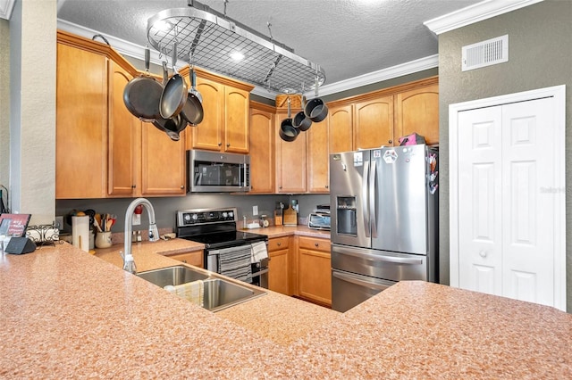 kitchen featuring stainless steel appliances, light countertops, visible vents, ornamental molding, and a textured ceiling