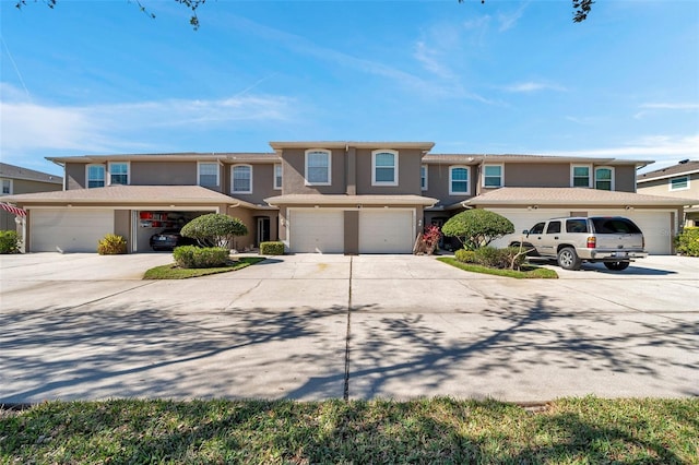 view of front of property featuring a garage, driveway, and stucco siding