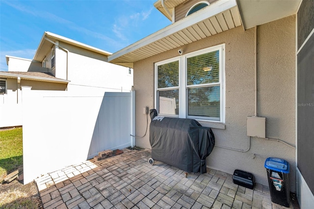 view of patio featuring a grill and fence