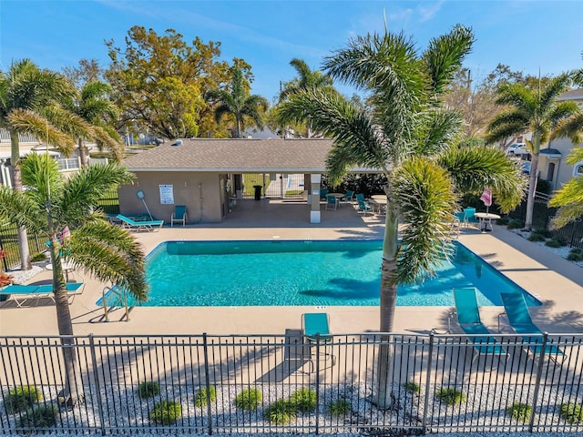 pool with a patio and fence