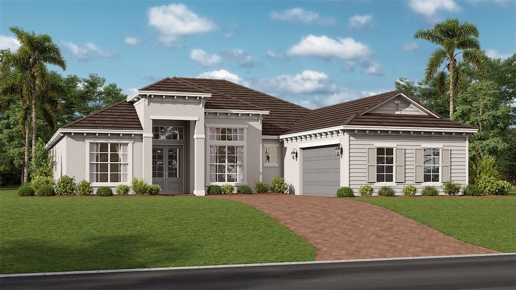 view of front of property with a garage, a tile roof, decorative driveway, and a front yard