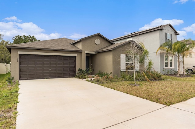 ranch-style house featuring a garage, concrete driveway, a front yard, and stucco siding