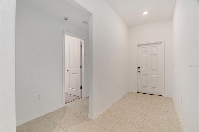 corridor featuring light tile patterned floors, recessed lighting, and baseboards