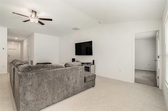 living area with vaulted ceiling, light tile patterned floors, visible vents, and a ceiling fan