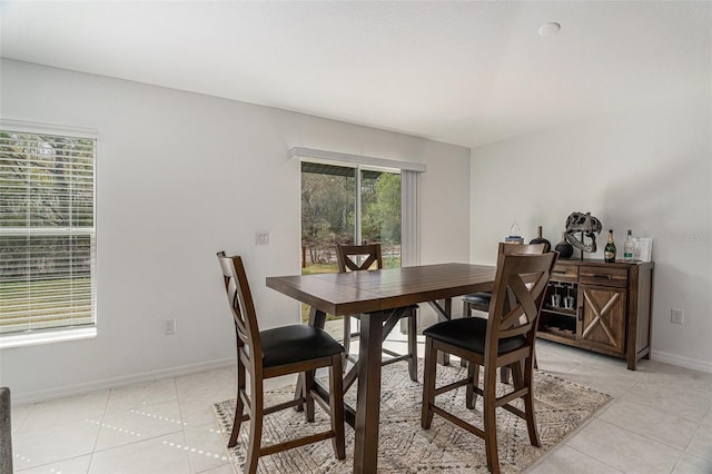 dining space with light tile patterned floors and baseboards